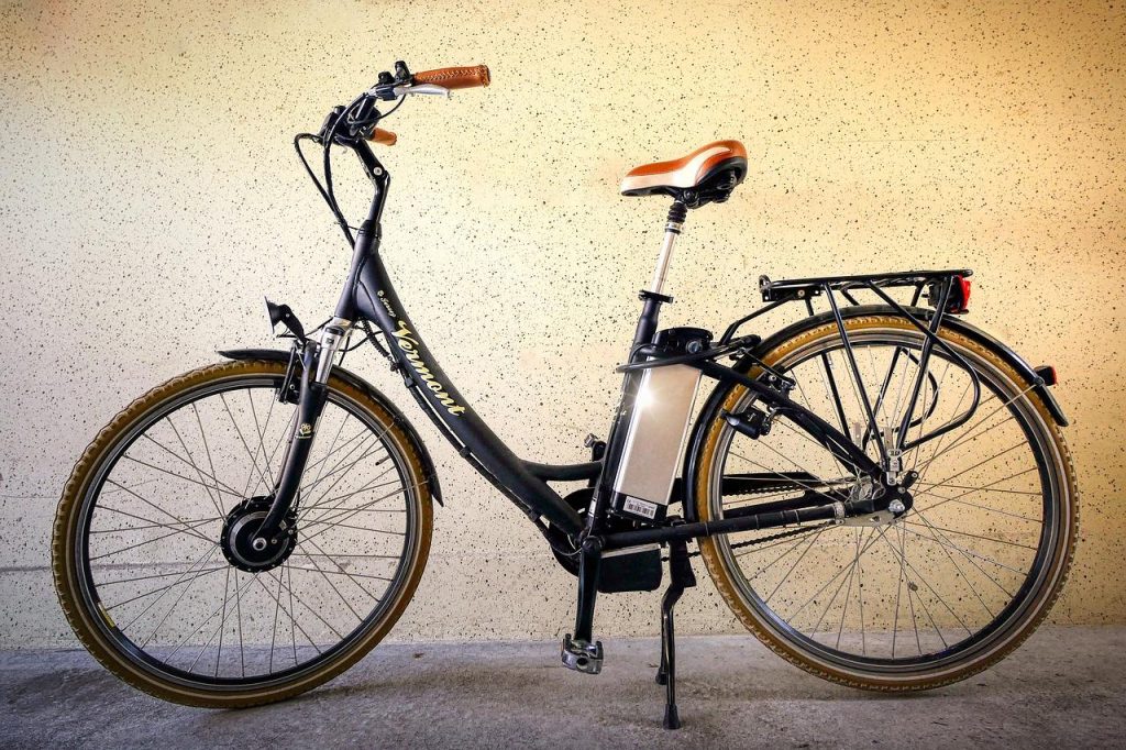 Fietsenwinkel Enschede: monteur controleert remmen en stuur van een fiets met professionele werkplaats op achtergrond